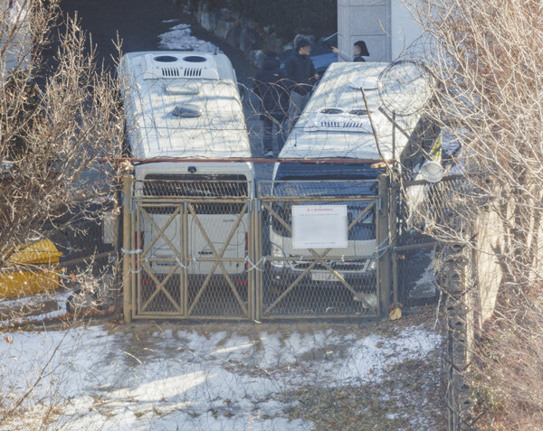법원이 윤석열 대통령에 대한 체포영장을 재발부해 공조수사본부 차원의 영장 2차 집행 시도가 초읽기에 들어간 9일 오전 서울 용산구 한남동 대통령 관저에서 경호처 직원이 철조망이 쳐진 쪽문을 버스로 벽을 치고 있다.이 쪽문은 전날 쇠사슬을 묶었고, 이날 버스로 차벽을 추가했다. [사진=연합뉴스]