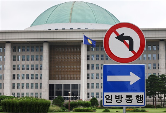 양당의 적대적 공생에 의해 운영되는 국회의사당. 국회 정문 입구에 설치된 일방통행, 좌회전금지 교통 표지판 너머로 본청이 보인다. [사진=연합뉴스]