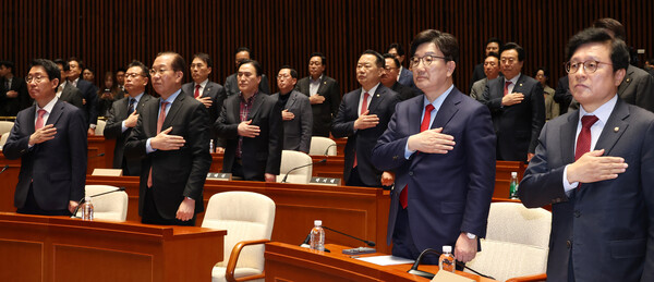 국민의힘 권영세 비상대책위원장과 권성동 원내대표 등 의원들이 헌재의 윤석열 대통령 탄핵 인용이 발표된 4일 서울 여의도 국회에서 열린 긴급 의원총회에서 국기에 경례하고 있다. [사진=연합뉴스]