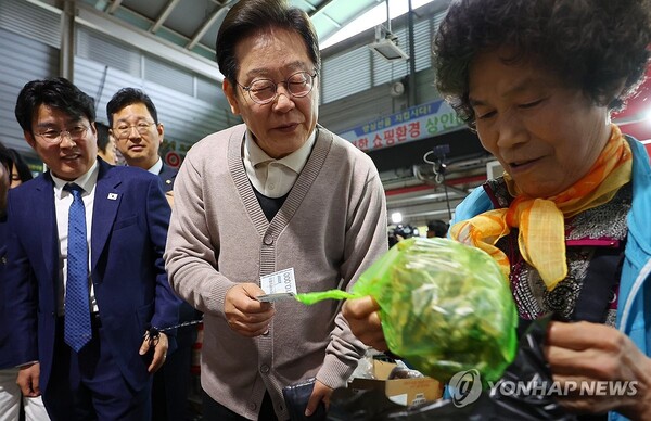 더불어민주당 이재명 대선 후보가 제3차 골목골목 경청투어로 경북지역 방문에 나선 9일 경북 영천시 영천공설시장을 찾아 한 가게에서 영천사랑상품권으로 말린 고추를 구매하고 있다. [사진=연합뉴스]