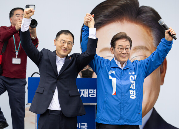 더불어민주당 이재명 대선후보가 16일 전북 익산시 익산역 동부광장에서 열린 유세에서 무소속 김상욱 의원과 손을 들어 인사하고 있다. [사진=연합뉴스]