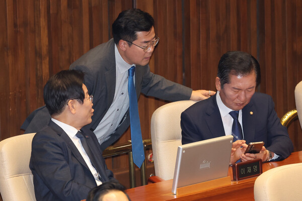 더불어민주당 이재명 대표와 박찬대 원내대표(가운데), 정청래 의원(오른쪽)이 11일 오후 대정부 질문이 진행된 국회 본회의장에서 휴대전화를 함께 보며 대화하고 있다. [사진=연합뉴스]