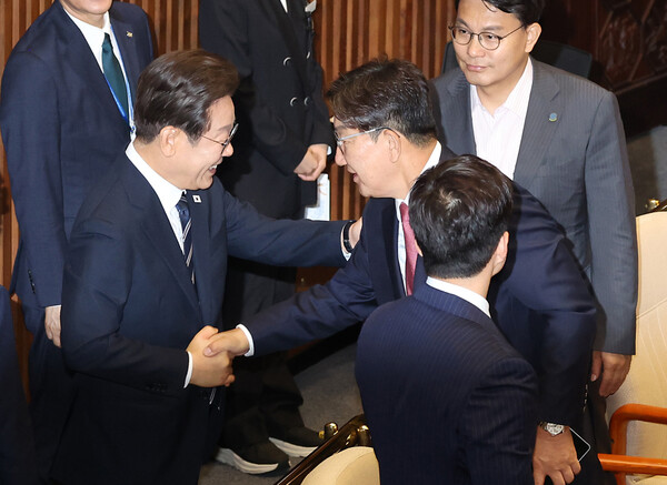  이재명 대통령이 26일 추가경정예산 시정연설을 마친 뒤 국회 본회의장에서 국민의힘 권성동 의원과 인사하고 있다. [사진=연합뉴스]