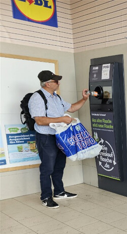 패트병을 회수함에 넣고 있는 주민