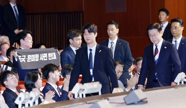  국민의힘 안철수 의원이 15일 서울 세종문화회관에서 열린 80주년 광복절 경축식에서 이재명 대통령이 경축사를 마치고 자리를 향할 때 '조국·윤미향 사면 반대'라는 문구가 적힌 펼침막을 들어보이고 있다. [사진=대통령실통신사진기자단]