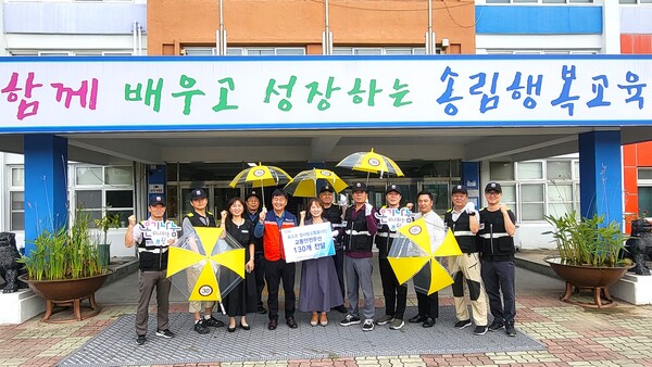 포항시자원봉사센터와 포스코 참사랑교통봉사단이 19일 송림초등학교 전교생을 대상으로 교통안전 우산 130개를 전달했다. / 사진=포항시자원봉사센터