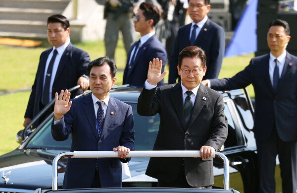 이재명 대통령이 1일 충남 계룡대 대연병장에서 열린 건군 77주년 국군의 날 기념행사에서 열병차량에 탑승해 손을 흔들고 있다. 왼쪽은 안규백 국방부 장관. [사진=연합뉴스]