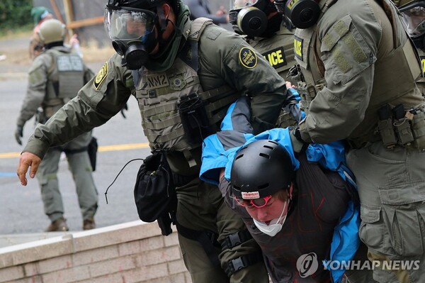 미국 연방요원들이 4일(현지시간) 오리건주 포틀랜드의 이민세관단속국(ICE) 본부 앞에서 시위 참가자를 체포하고 있다 [사진=로이터=연합뉴스]