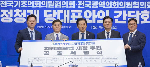 더불어민주당 정청래 대표가 18일 국회에서 열린 전국기초·광역의회의원협의회 간담회에서 지방의회 의원 협의회 대표들과 지방의회 발전과 위상제고를 위한 지방의회법 제정 추진 공동서명서에 서명한 뒤 들어 보이고 있다. [사진=연합뉴스]