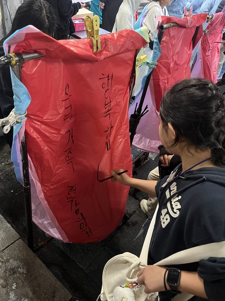 가족의 건강과 행복을 기원하는 메세지를 천등에 메모하고있다.