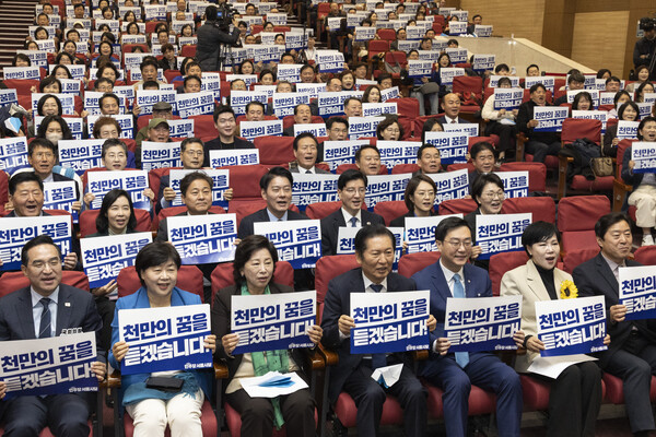 더불어민주당 정청래 대표(왼쪽 네 번째)와 장경태 서울시당 위원장(왼쪽 다섯 번째)을 비롯한 의원들과 당원들이 25일 국회 의원회관에서 열린 민주당 서울시당 '천만의 꿈 경청단' 출범식에 참석해 손팻말을 들고 구호를 외치고 있다.