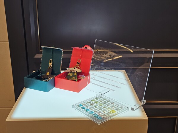 남도, 빛의 바다'는 버려진 전복껍데기를 활용해 근대 문화유산을 재해석한 작품으로, '근대 의상 열쇠고리'와 '전복빛 브로치'[사진제공 = 진도군]